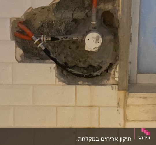 צינורות חשופים בקיר עם חור